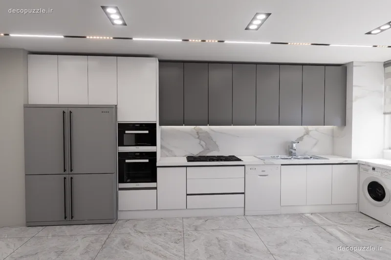کابینت مدرن دورنگ سفید و طوسی مات با فر توکار، مایکروویو توکار و بین کابینتی ماربل در آشپزخانه خطی