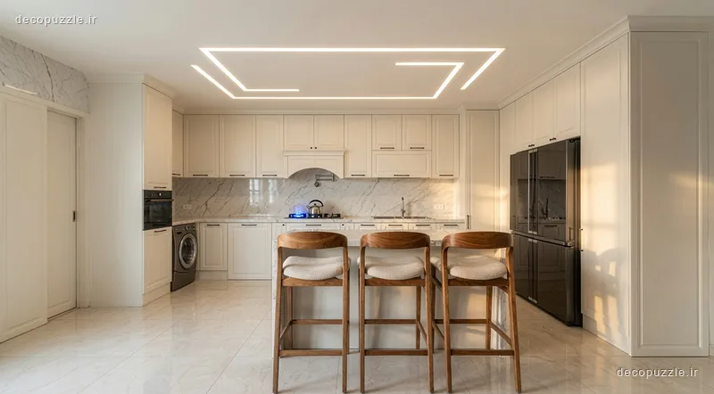 آشپزخانه نئوکلاسیک با کابینت کرم، جزیره، بین کابینتی ماربل و نورپردازی خطی